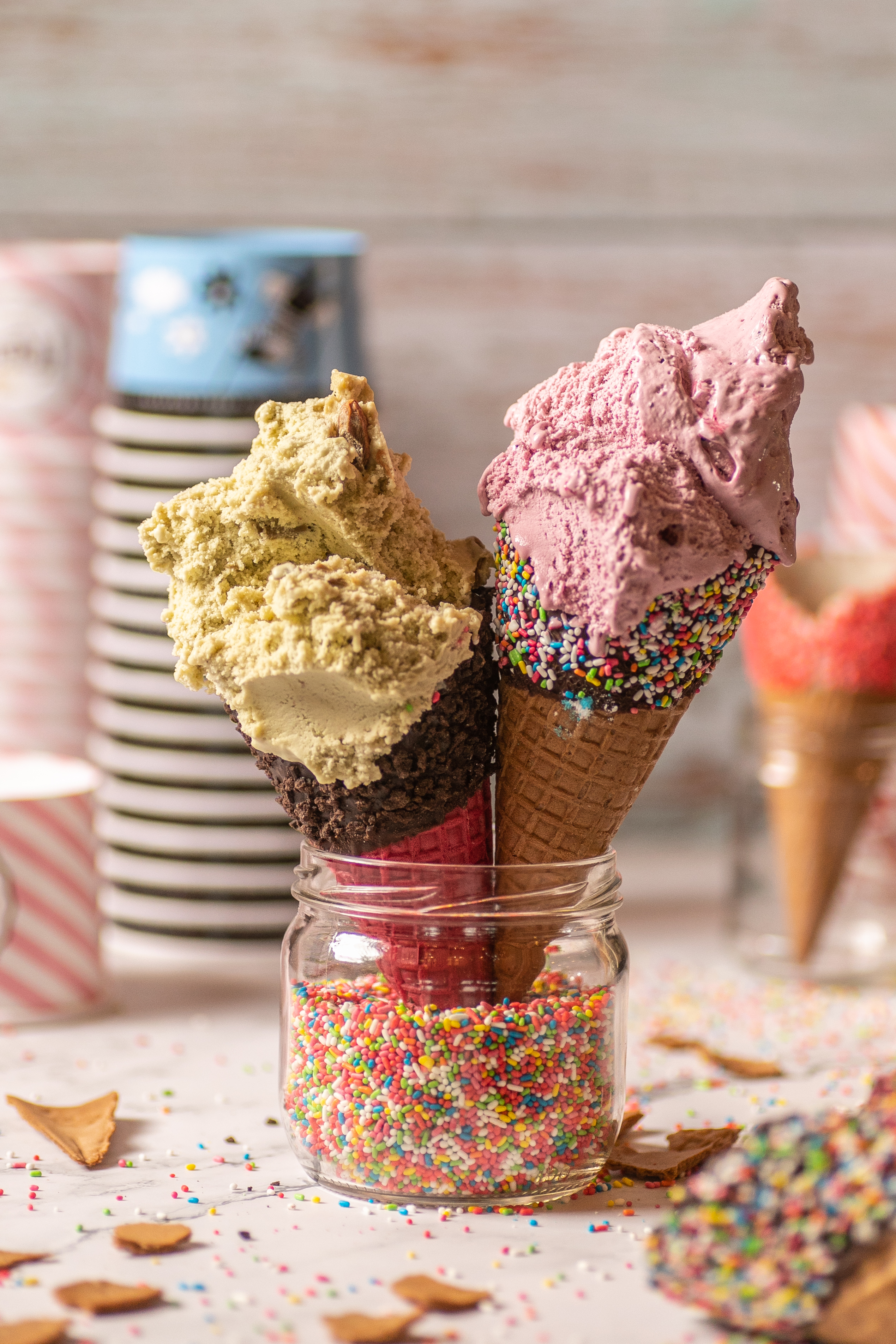 Colorful Fregio ice cream cones with pistachio and berry flavors in sprinkle-coated wafers