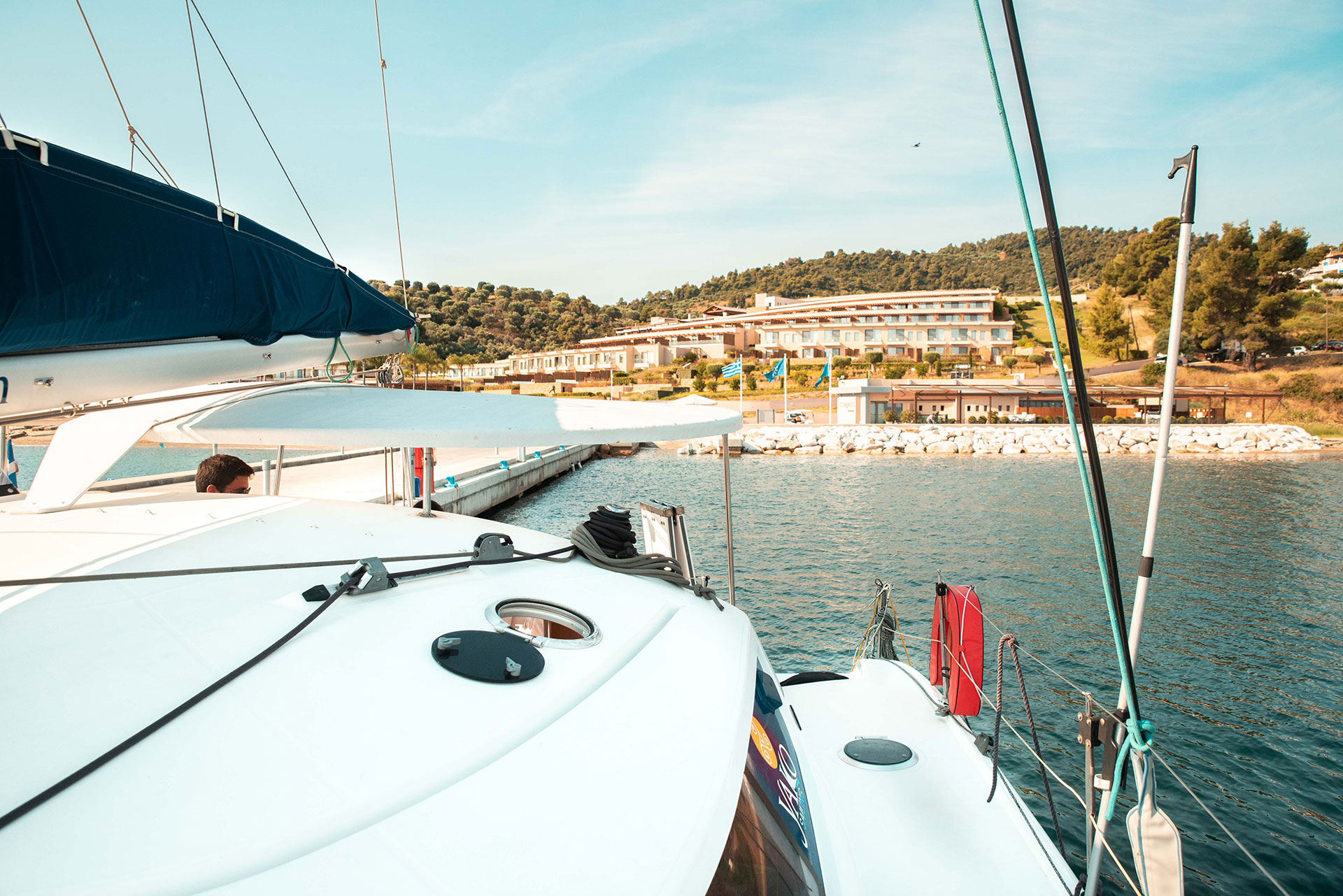 View from a yacht approaching the marina with the resort and green hills in the background