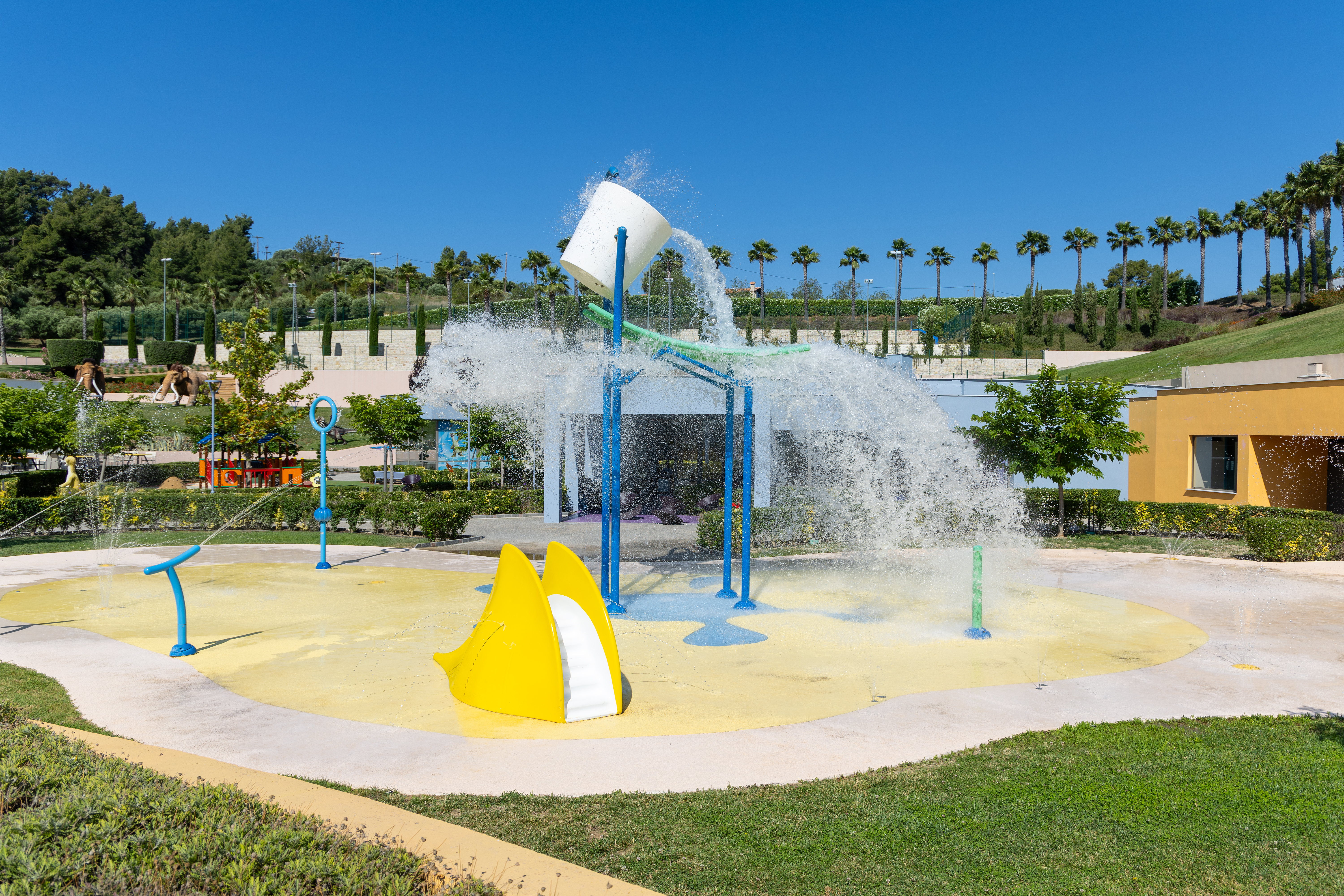 Fun outdoor splash park with water jets and tipping bucket at Kids Planet