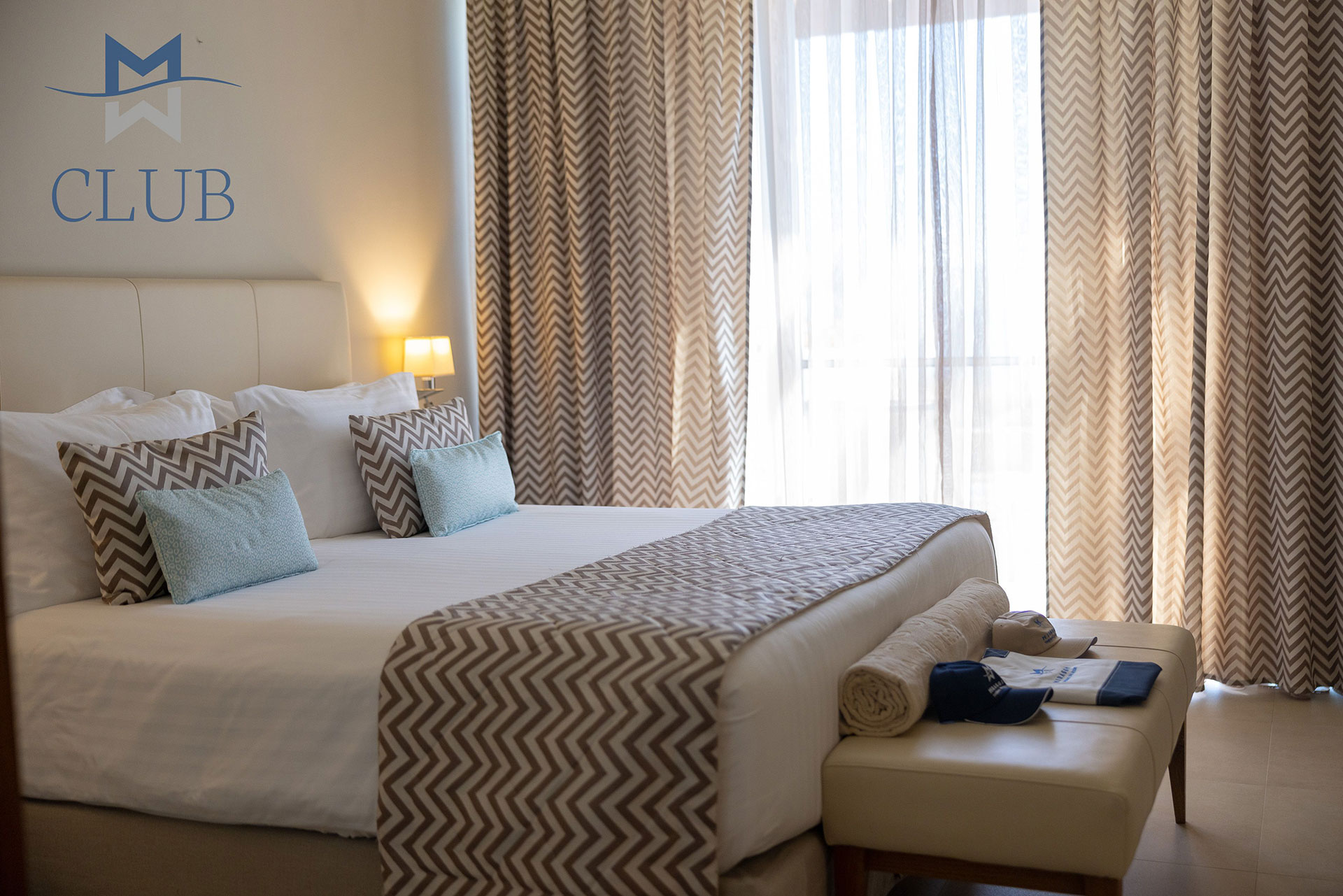 Close up to king size bed in suite's bedroom with natural lighting and modern design