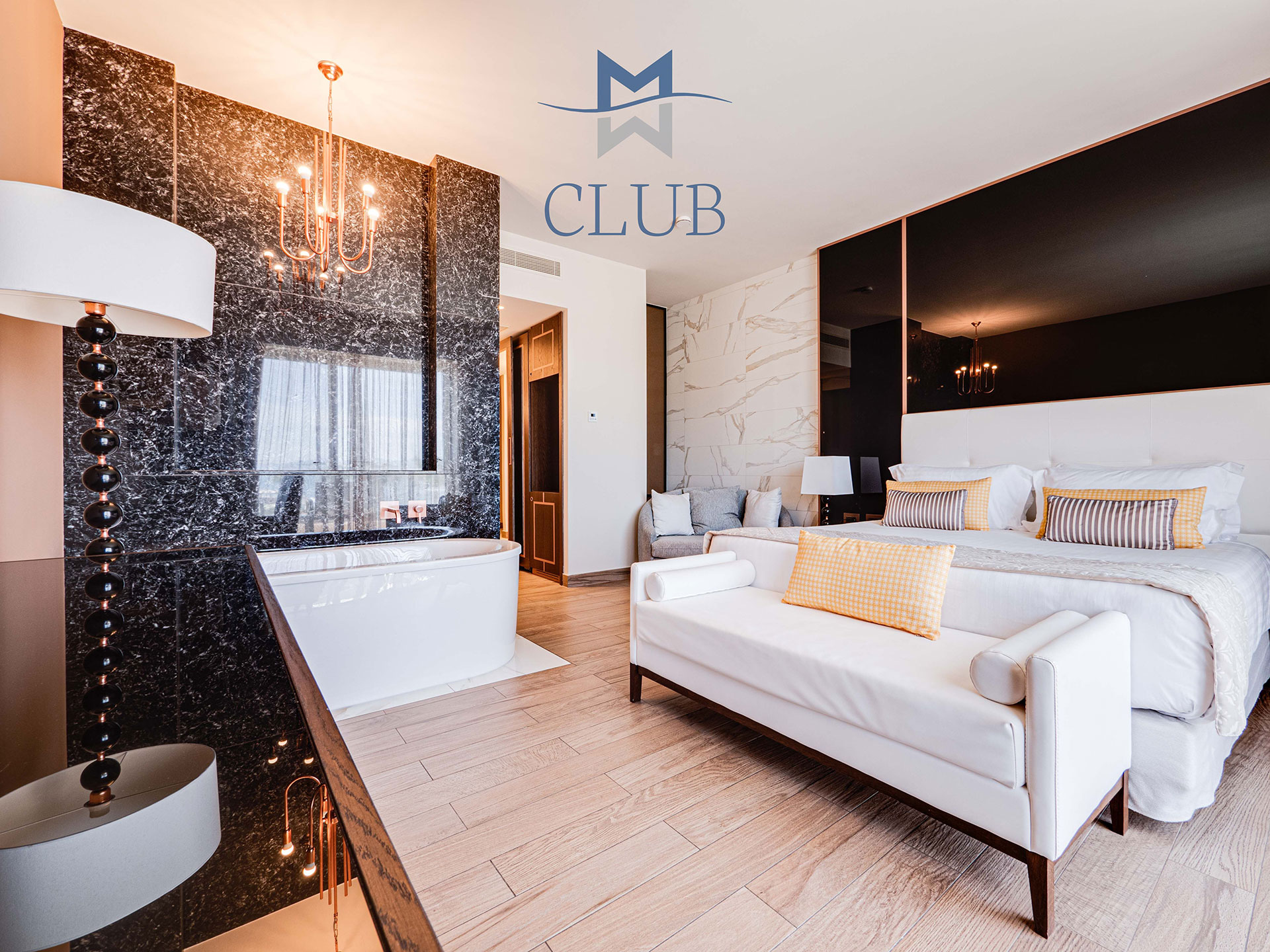 Elegant duplex suite bedroom with marble wall, chandelier, king size bed and black stylish accents