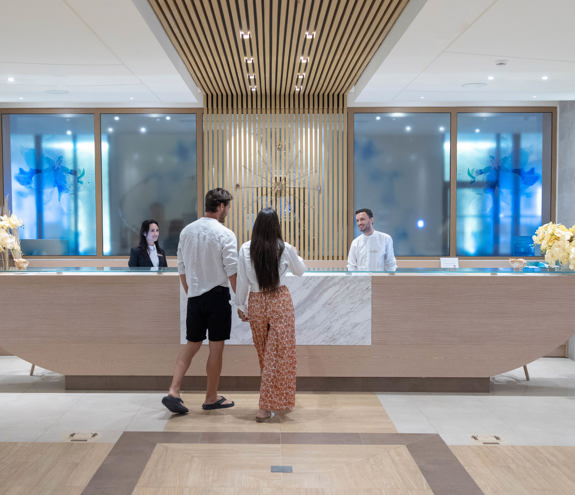Couple being assisted at the spa reception desk with warm hospitality