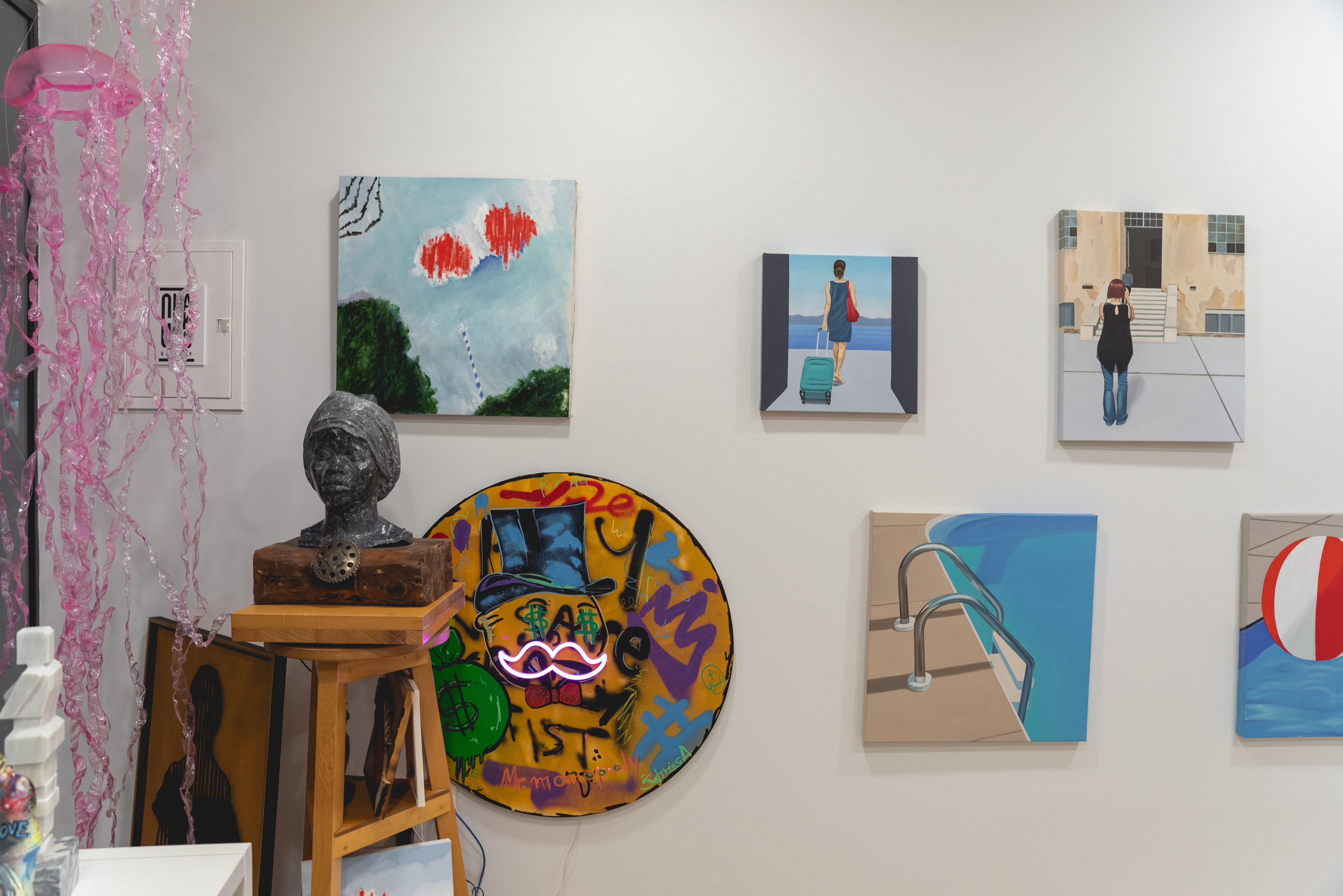 Art gallery corner with bust sculpture, neon artworks, and pink jellyfish decorations hanging from the ceiling