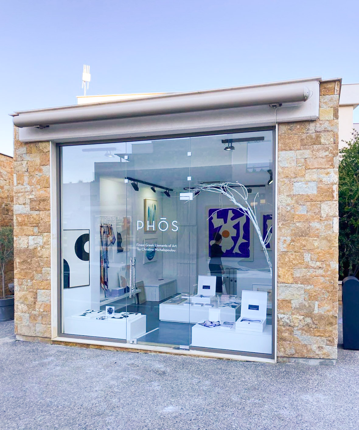 PHOS boutique exterior showcasing blue and white abstract paintings inside