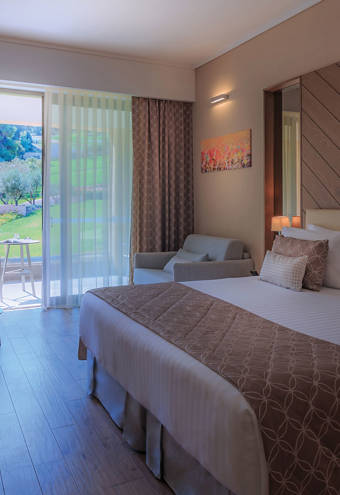 Superior Garden View Room bed, chair and armchairs alongside other amenities