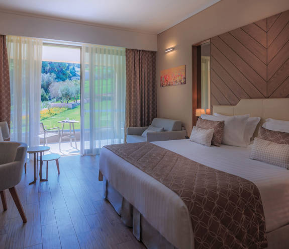 Superior Garden View Room bed, chair and armchairs alongside other amenities