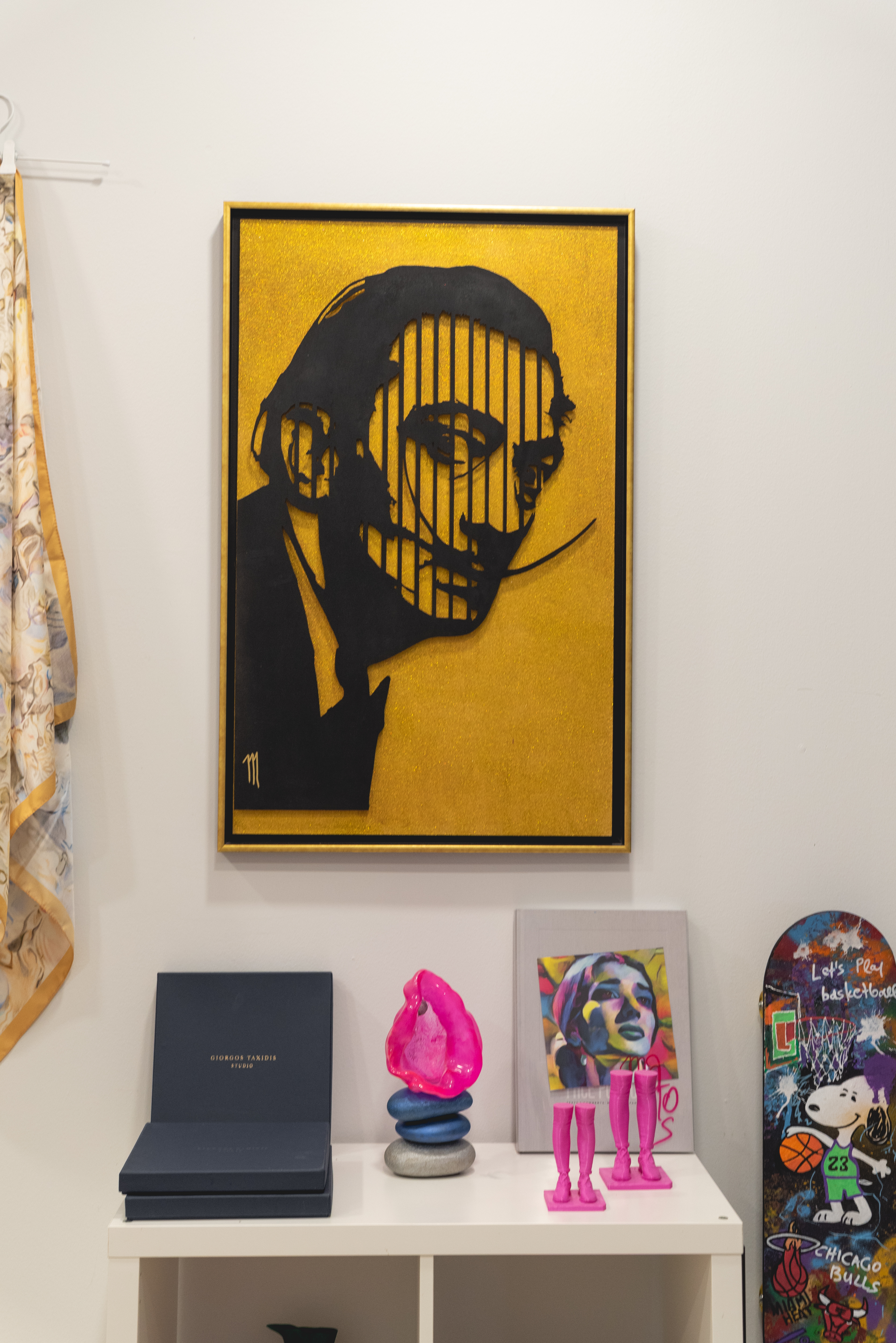 Portrait of Salvador Dali on a gold and black background displayed in the art gallery
