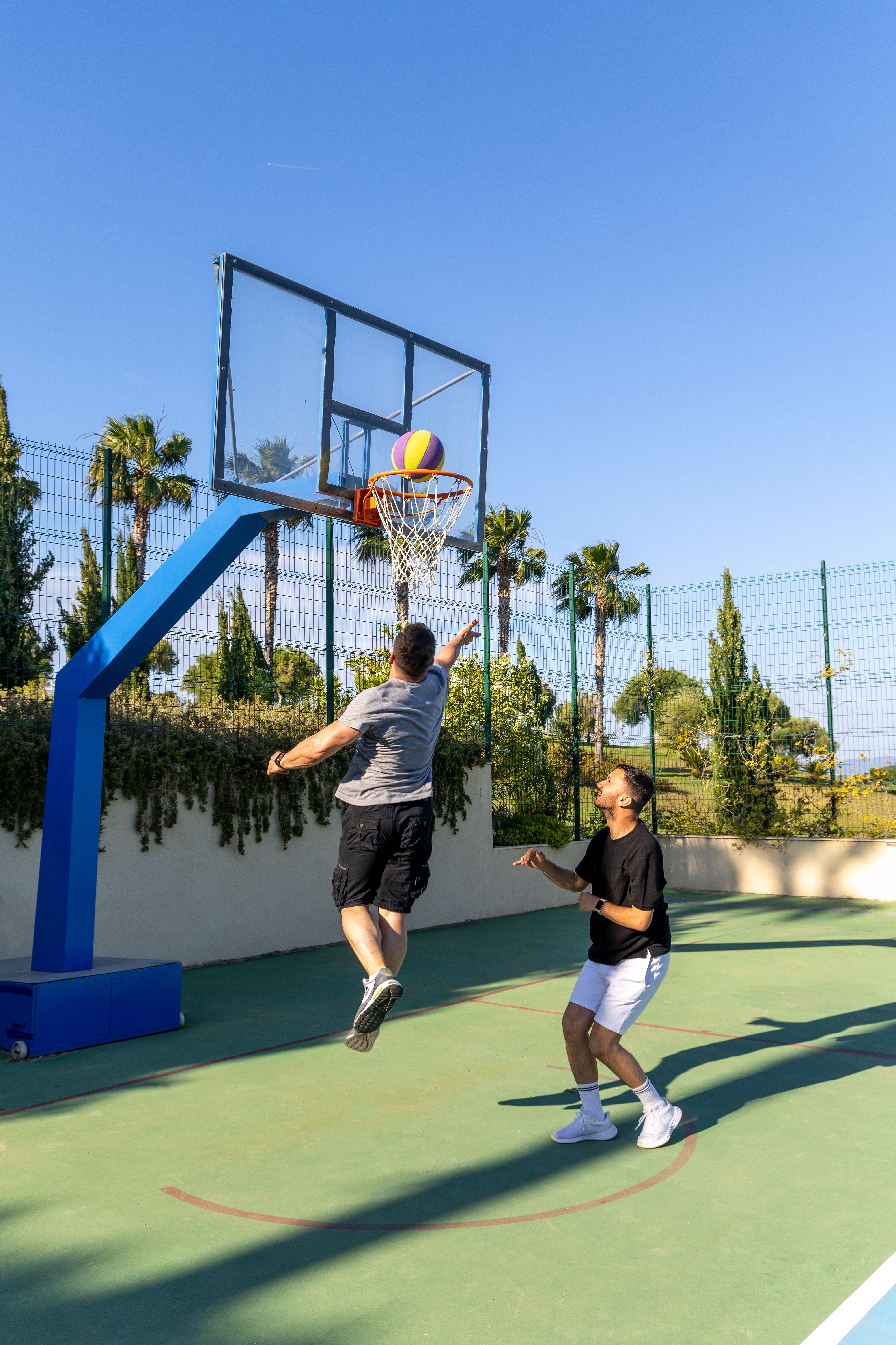 Basketball player jumping to score a basket on the outdoor court