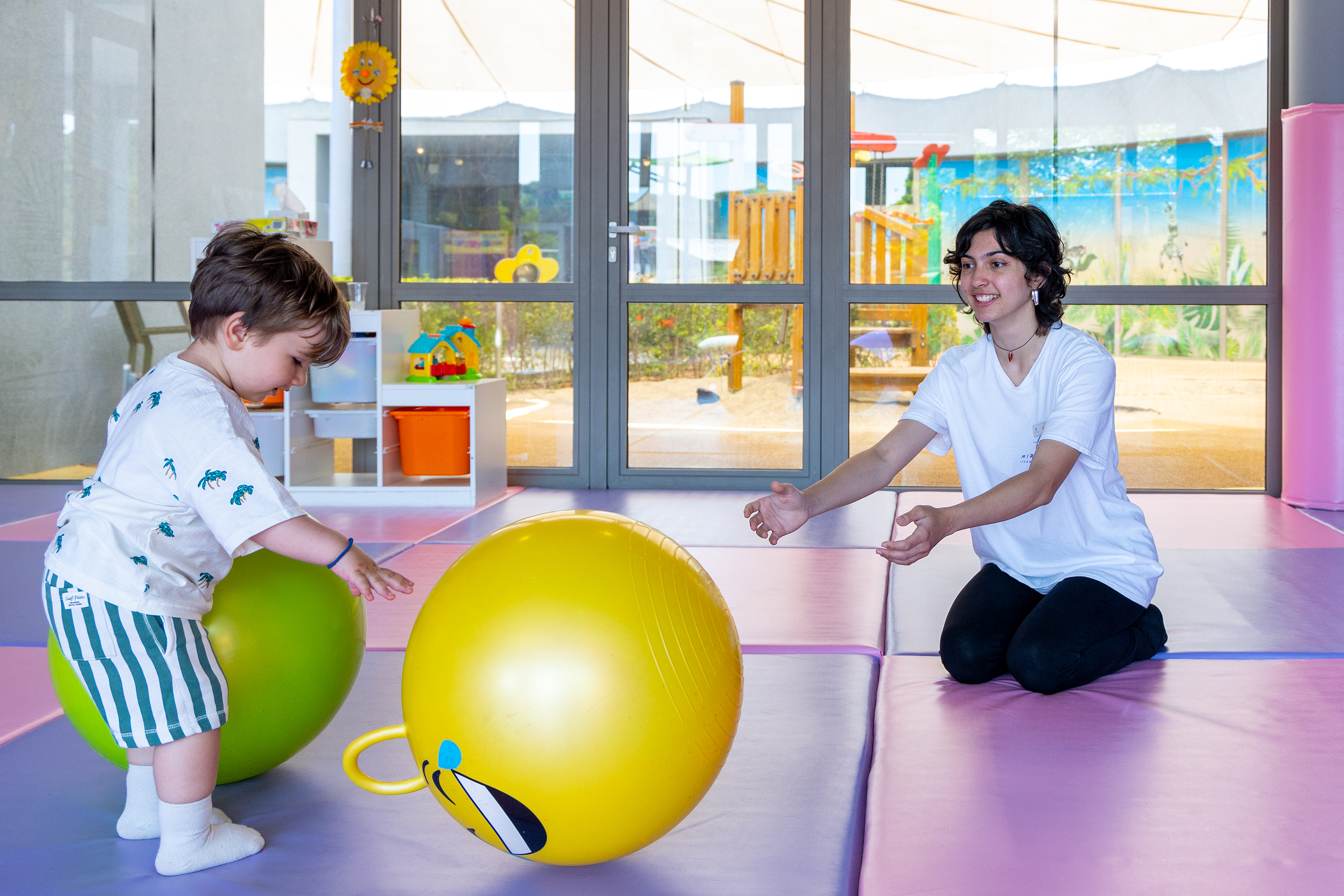 Child playing with colorful balls under supervision at the Kids Planet indoor play zone