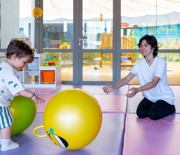 Child playing with colorful balls under supervision at the Kids Planet indoor play zone