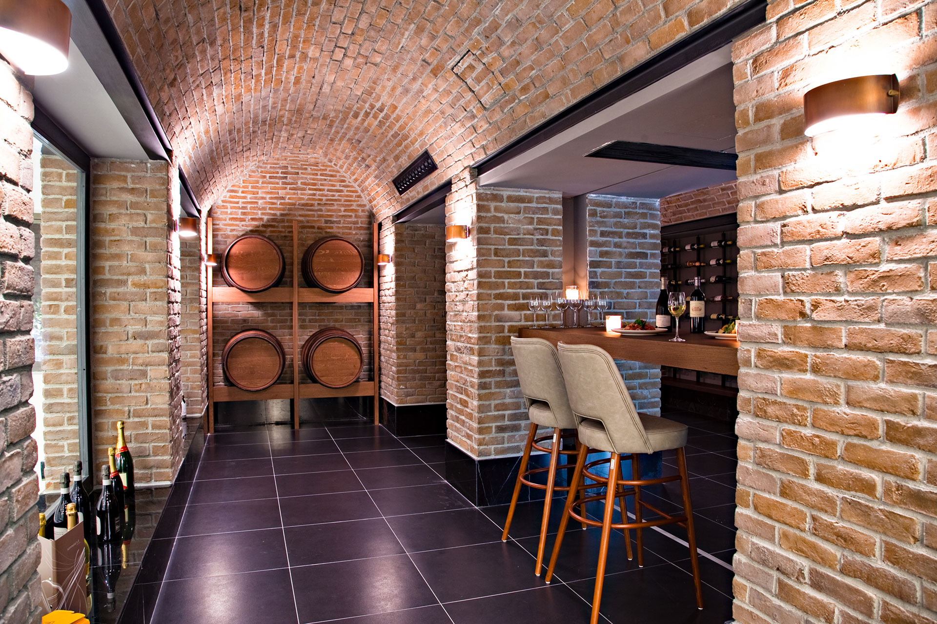 Sommelier's 8 restaurant's wine cellar with brick arches, wooden barrels and tasting counter